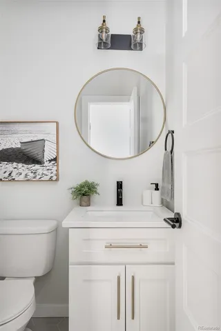 a bathroom with a sink mirror vanity and toilet