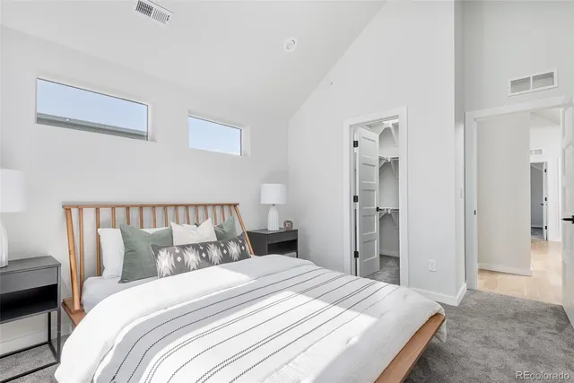 a bedroom with a large bed and wooden floor