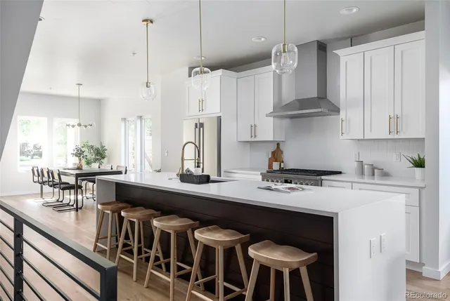 a kitchen with stainless steel appliances a table chairs and white cabinets