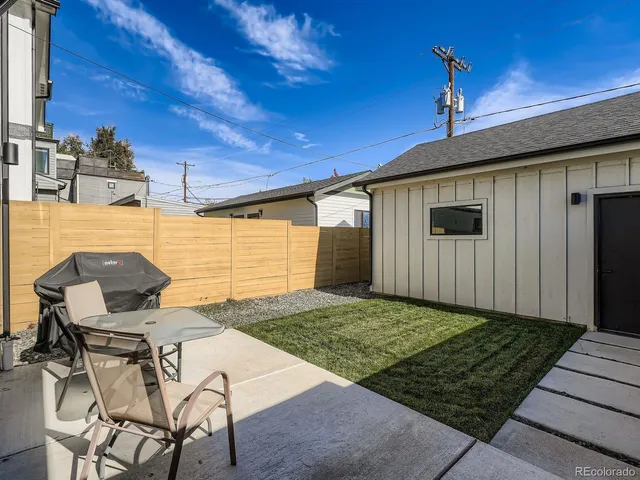 a backyard of a house with table and chairs