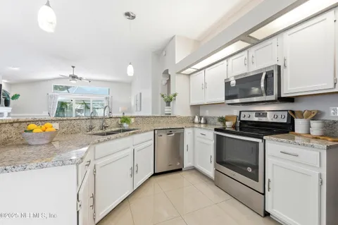 a kitchen with stainless steel appliances granite countertop a stove a sink and a microwave