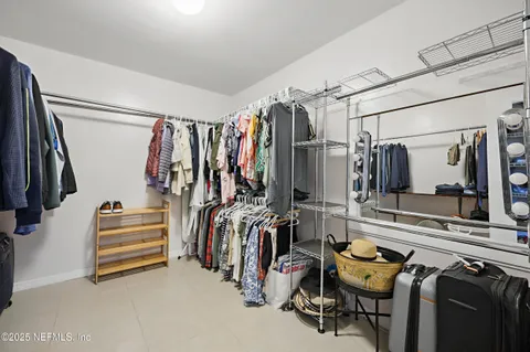 a view of walk in closet with clothes and shoes