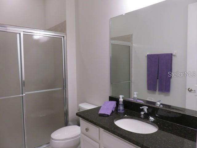6969 Indus Valley Circle Parrish, FL 34219 - Photo 25 of 49 a bathroom with a granite countertop sink toilet a mirror and shower