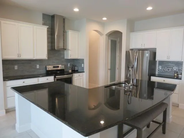 a kitchen with stainless steel appliances granite countertop a sink a microwave and a refrigerator