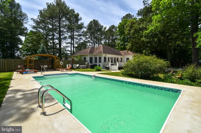 a swimming pool with outdoor seating and yard
