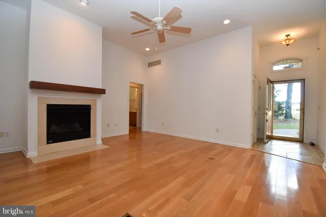 a view of an empty room with a fireplace and a window