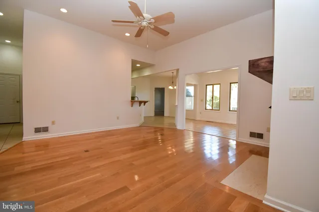 a view of an empty room with window and wooden floor