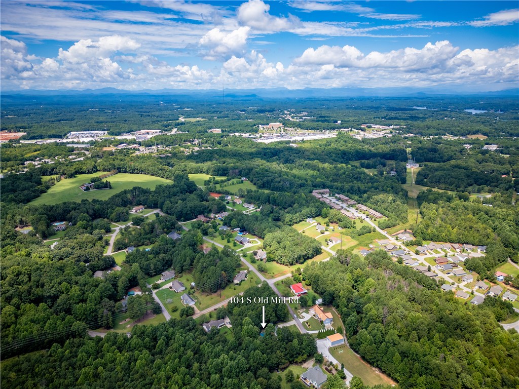 404 South Old Mill Road Seneca, SC 29678 - Photo 34 of 39 Lush green woodlands frame this aerial view of the surrounding rolling landscape and distant mountains.