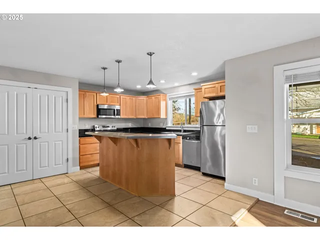 a kitchen with stainless steel appliances granite countertop a stove a sink and a microwave