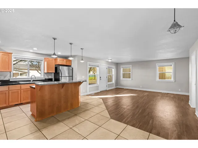 a kitchen with granite countertop a stove a sink and a refrigerator