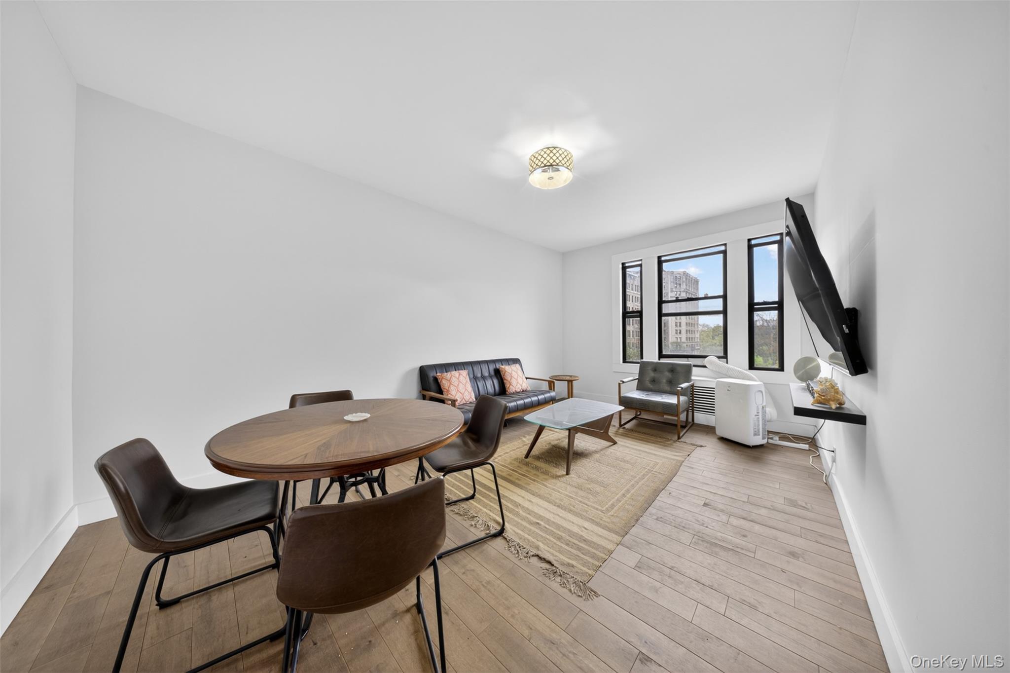 812 Riverside Drive, Unit 42 Manhattan, NY 10032 - Photo 7 of 19 a living room with furniture and a wooden floor