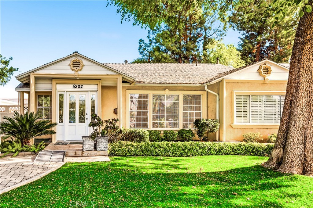 5204 Etiwanda Avenue Tarzana, CA 91356 - Photo 1 of 23 a front view of a house with a yard table and chairs