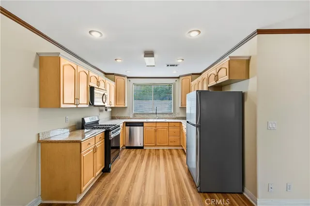 a kitchen with a refrigerator a sink dishwasher with a dining table and chairs