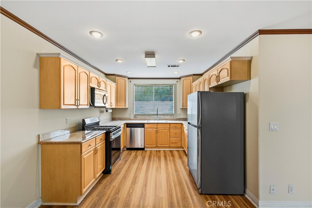 5204 Etiwanda Avenue Tarzana, CA 91356 - Photo 11 of 23 a kitchen with a refrigerator a sink dishwasher with a dining table and chairs