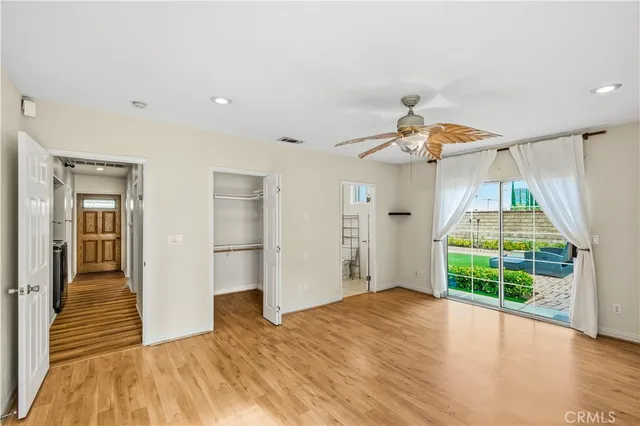 a view of a room with wooden floor fan and windows