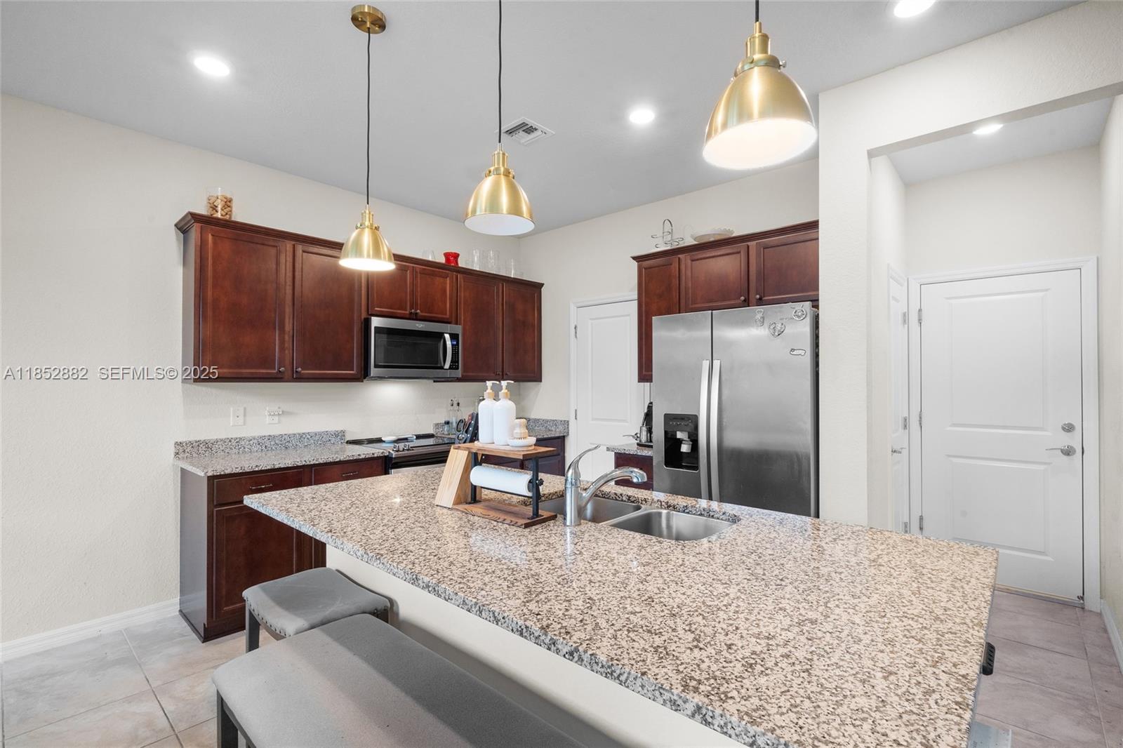 4248 Ficus Street Hollywood, FL 33021 - Photo 18 of 69 a kitchen with stainless steel appliances granite countertop a sink refrigerator and microwave