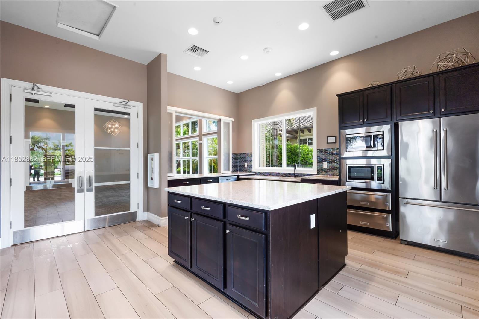 4248 Ficus Street Hollywood, FL 33021 - Photo 64 of 69 a kitchen with kitchen island granite countertop a refrigerator and wooden cabinets
