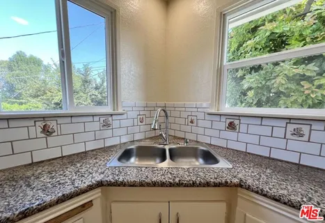 a kitchen with a sink a granite counter top and a window