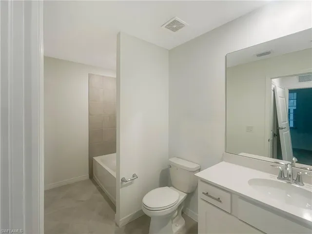 a bathroom with a sink a toilet a mirror and vanity