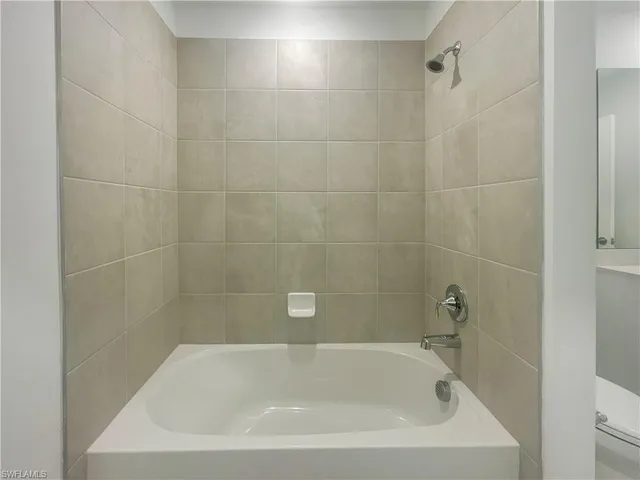 a white bath tub sitting next to a white sink and vanity