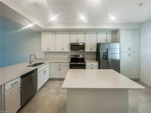 a kitchen with a refrigerator and a sink
