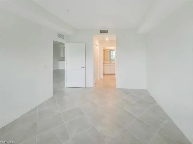 a view of an empty room and chandelier fan