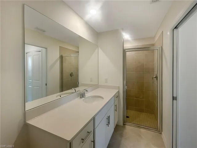 a bathroom with a shower sink and mirror