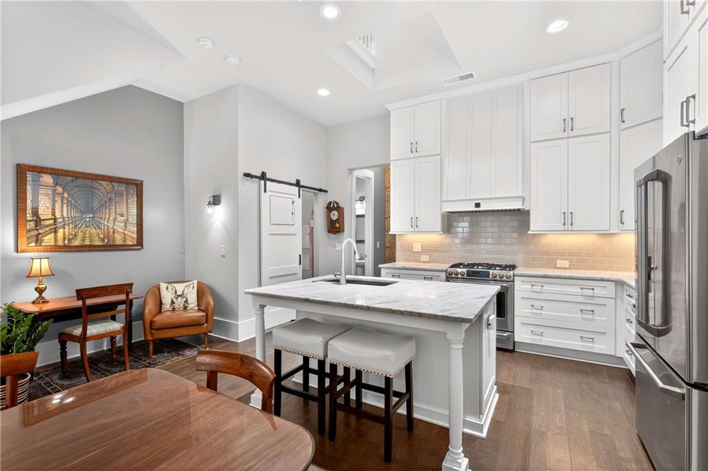 208 Sessions Street Woodstock, GA 30188 - Photo 14 of 47 a kitchen with stainless steel appliances a stove a refrigerator a white table and chairs