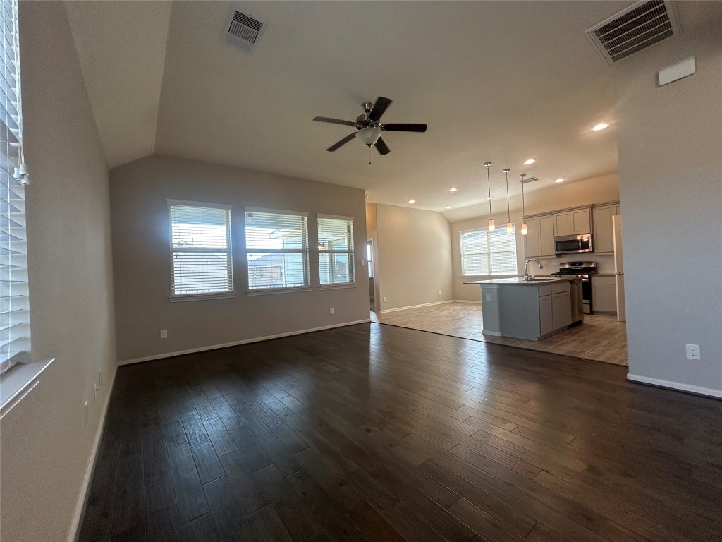 3132 Dunsmore Manor Court Spring, TX 77386 - Photo 6 of 18 an empty room with wooden floor kitchen view and windows