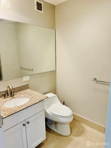 a bathroom with a granite countertop bathtub shower and toilet