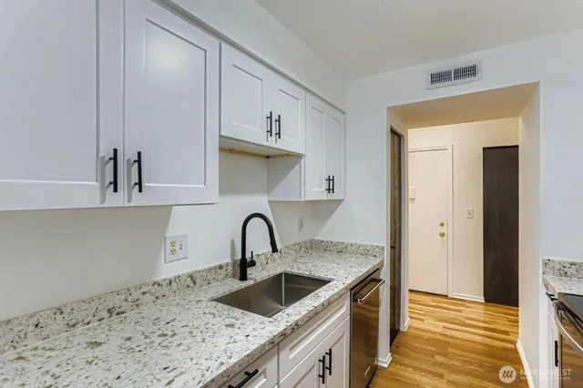 a kitchen with stainless steel appliances granite countertop a sink and a stove