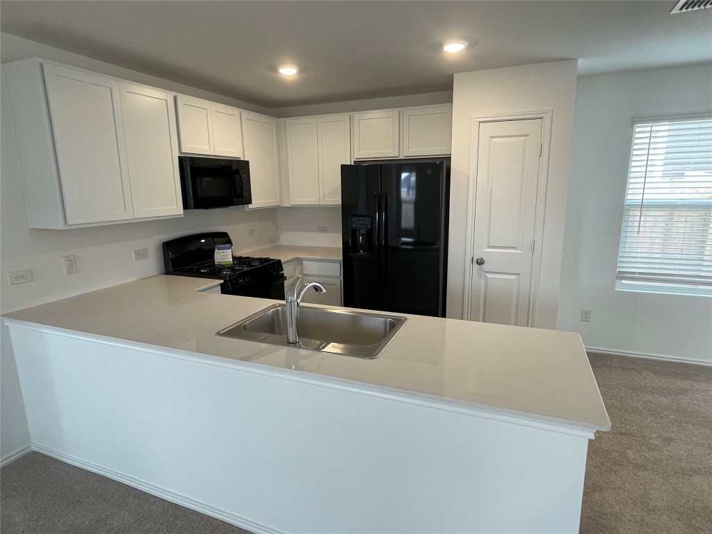 576 Avre Loop Kyle, TX 78640 - Photo 8 of 11 a kitchen with stainless steel appliances a refrigerator sink and microwave