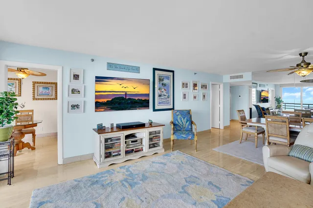 a dining room with furniture water view and a floor to ceiling window