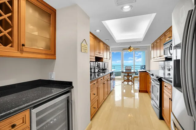 a large kitchen with stainless steel appliances granite countertop a sink a stove and cabinets