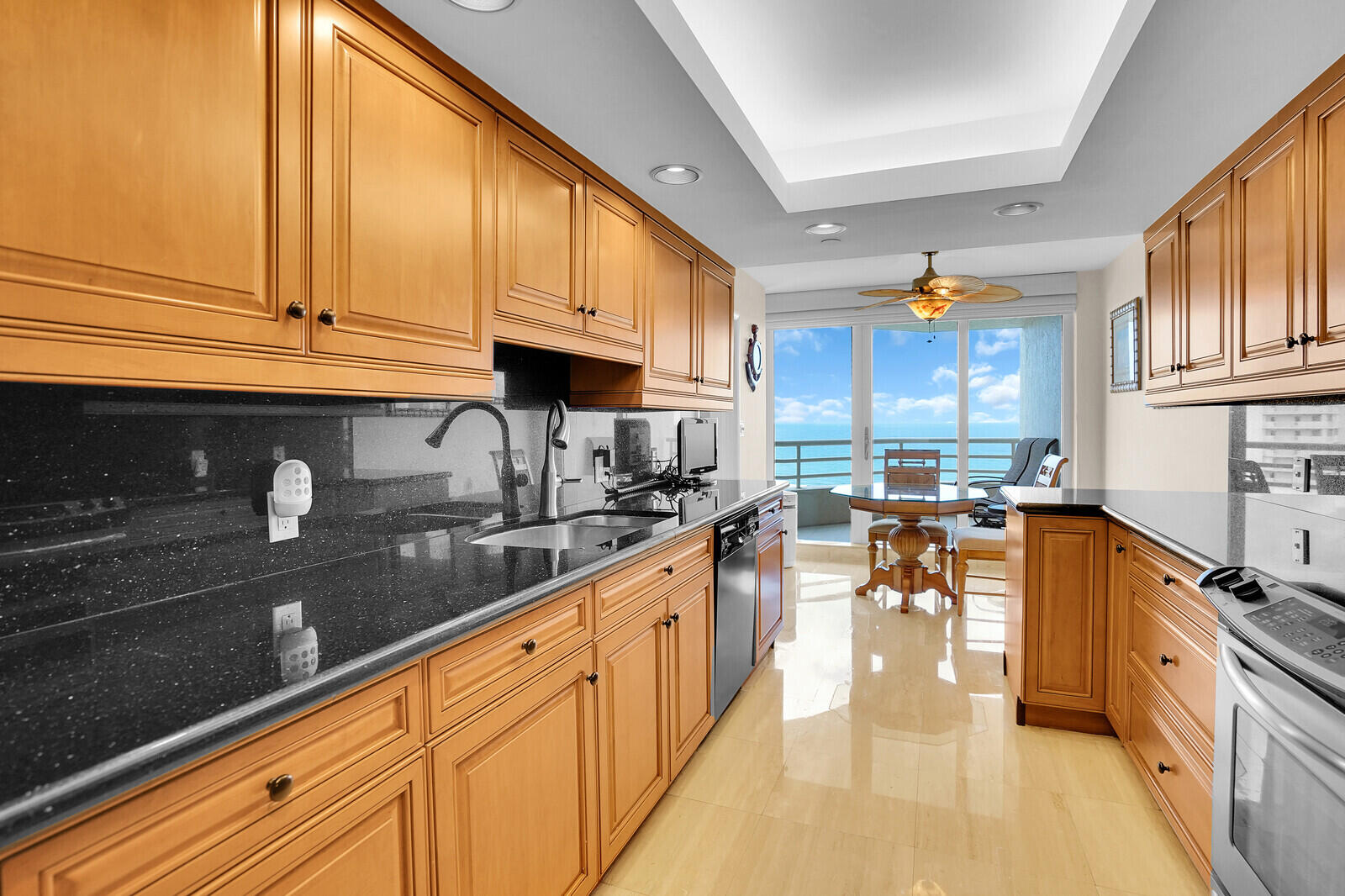 4101 North Ocean Boulevard, Unit 1604 Boca Raton, FL 33431 - Photo 24 of 51 a kitchen with stainless steel appliances granite countertop a sink a stove and a wooden floors
