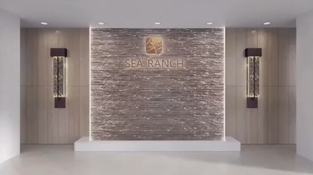 a view of a hallway with stainless steel appliances a refrigerator and chandelier