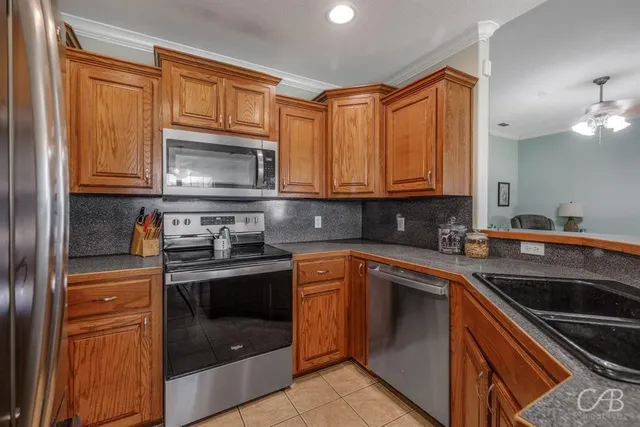 a kitchen with stainless steel appliances granite countertop a sink a refrigerator and microwave