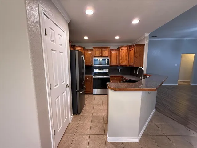 a view of kitchen with stainless steel appliances granite countertop a sink and a counter top space