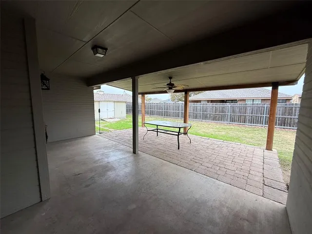 a view of a patio with a table chairs and a backyard