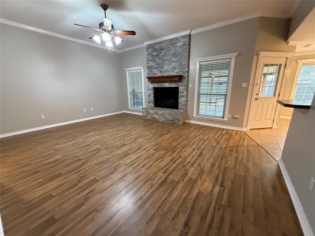 1302 Lewis And Clark Trail Abilene, TX 79602 - Photo 3 of 37 a view of an empty room with wooden floor fireplace and a window