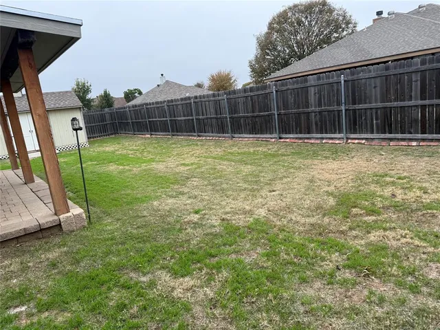a view of a green field with wooden fence