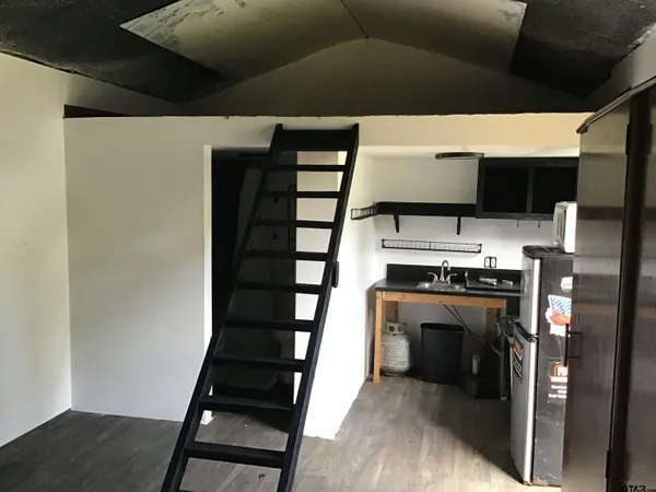 a view of kitchen with a sink fire place and refrigerator