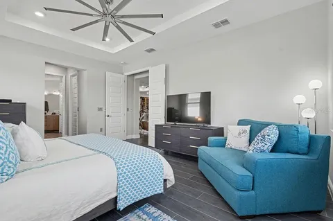 a bedroom with a bed a couch and a flat screen tv
