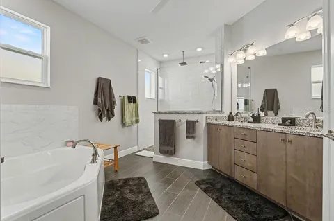 a bathroom with a tub sink and mirror