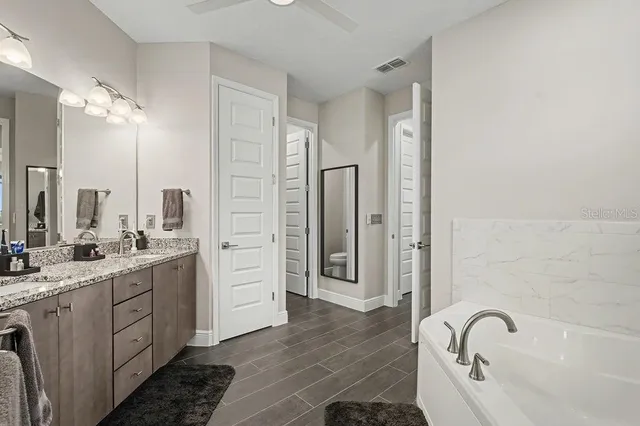 a bathroom with a double vanity sink a mirror and a bathtub