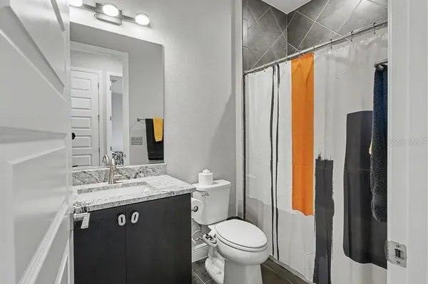 a bathroom with a sink vanity mirror and toilet