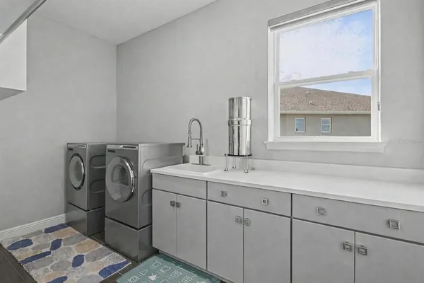 a utility room with a sink dryer and next to a window