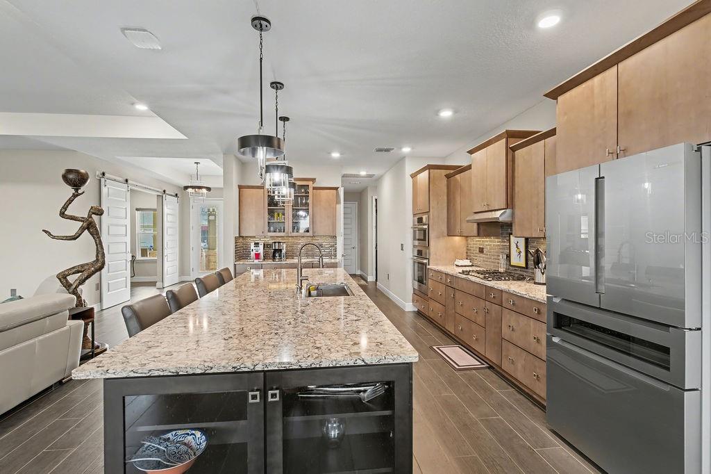 9963 Southwest 82nd Street Road Ocala, FL 34481 - Photo 9 of 43 a kitchen with granite countertop kitchen island stainless steel appliances a sink cabinets and wooden floor