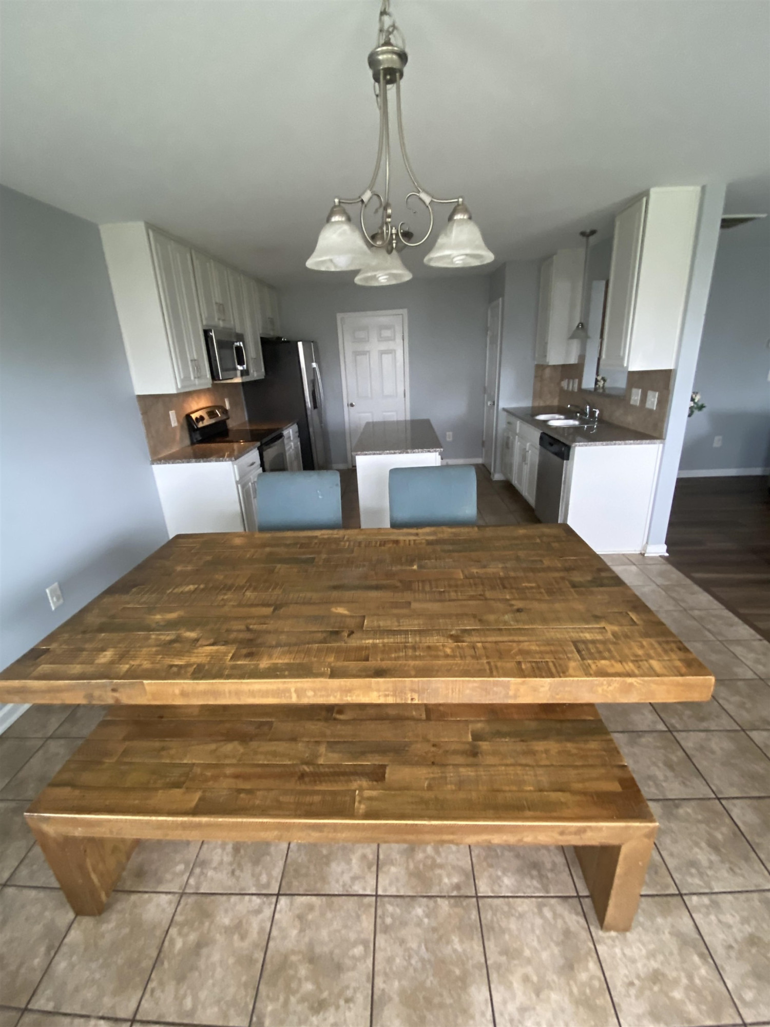95 Red Coat Drive Cameron, NC 28326 - Photo 11 of 35 a view of a kitchen with kitchen island stainless steel appliances granite countertop a stove top oven a sink dishwasher and a dining table with wooden floor