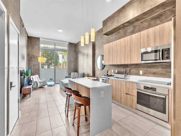 a kitchen with kitchen island granite countertop a sink stainless steel appliances and cabinets
